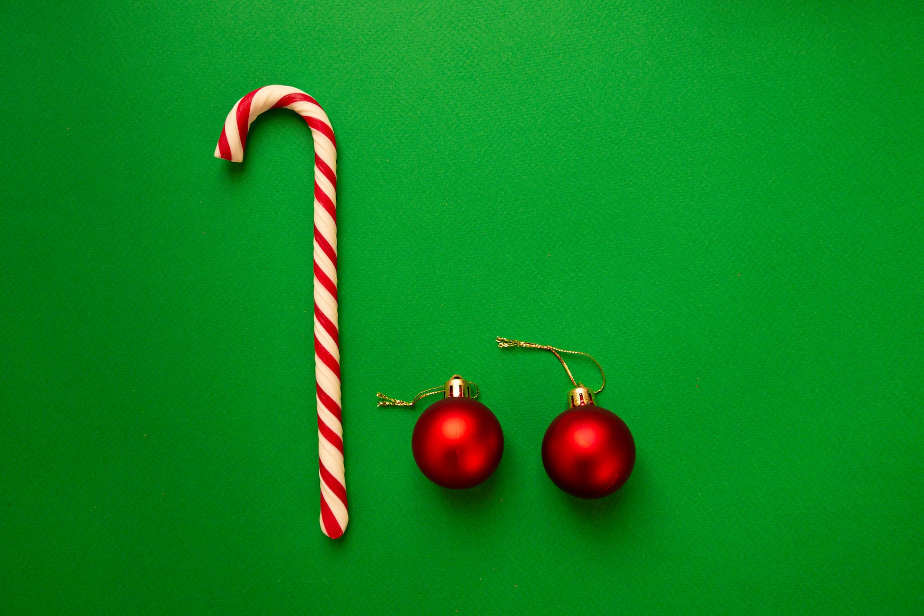 Photo by Victoria Emerson on <a href="https://www.pexels.com/photo/striped-christmas-candy-cane-and-red-baubles-placed-on-green-table-6037904/" rel="nofollow">Pexels.com</a>